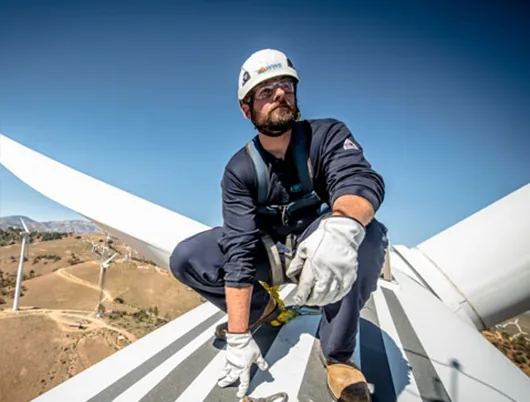 Technician inspecting turbine blades on site